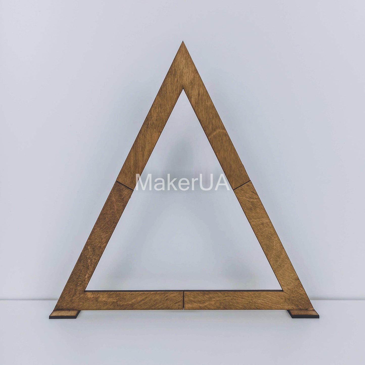 Large open triangular wooden A-frame arch with a natural brown wood finish. Boho chic geometric backdrop for outdoor wedding ceremonies and event photography.