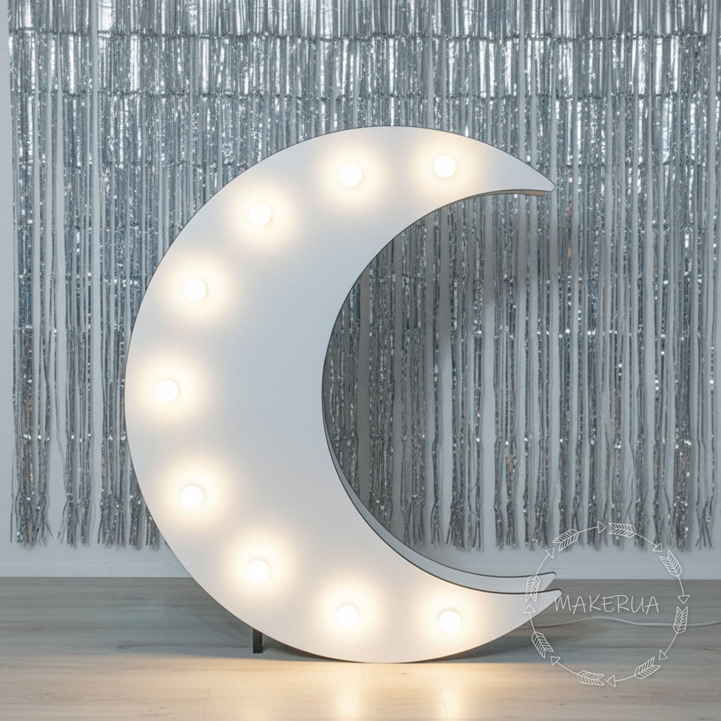 Decorative moon-shaped light fixture with bulbs against a silver curtain background