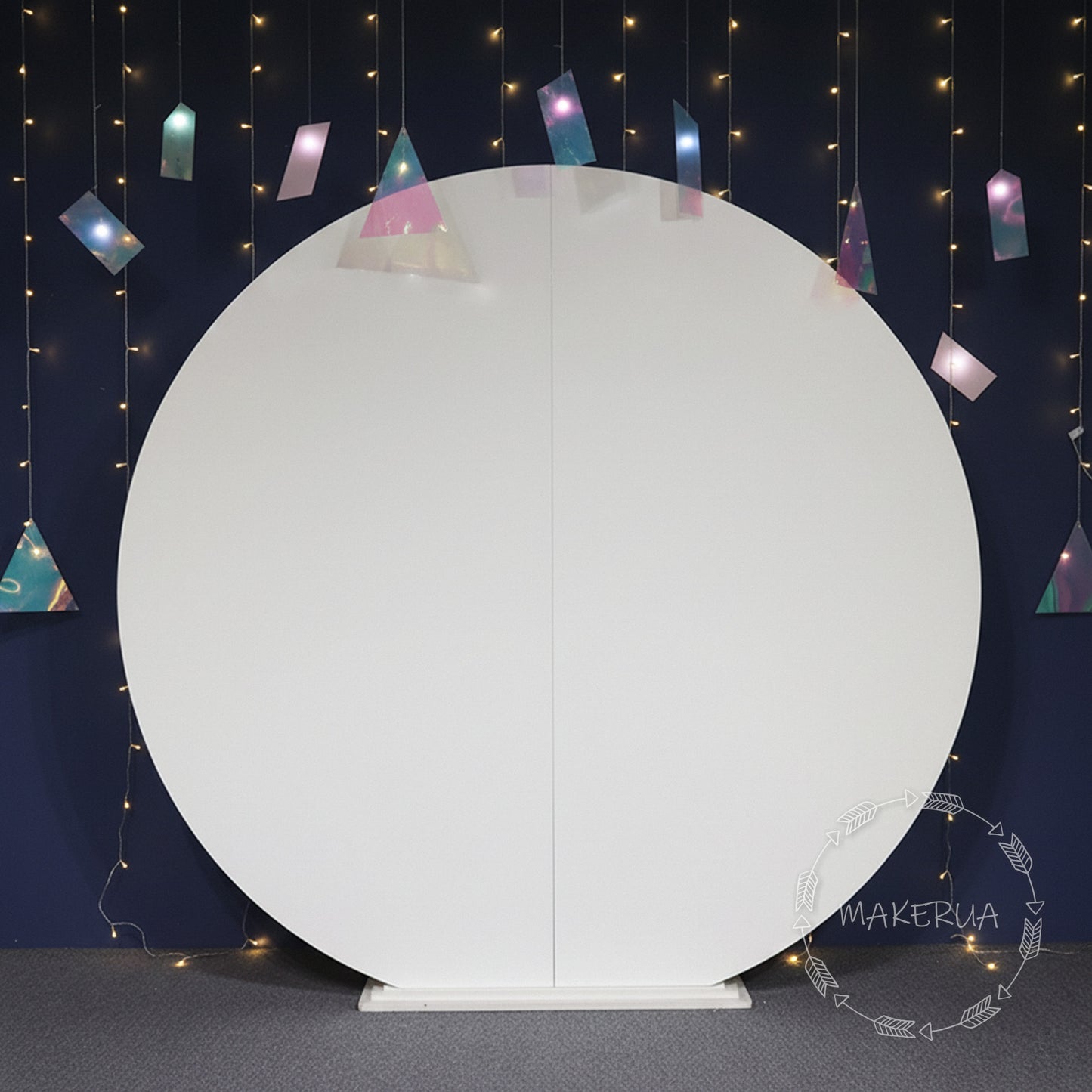 White round backdrop with colorful triangular flags against a dark blue wall with string lights