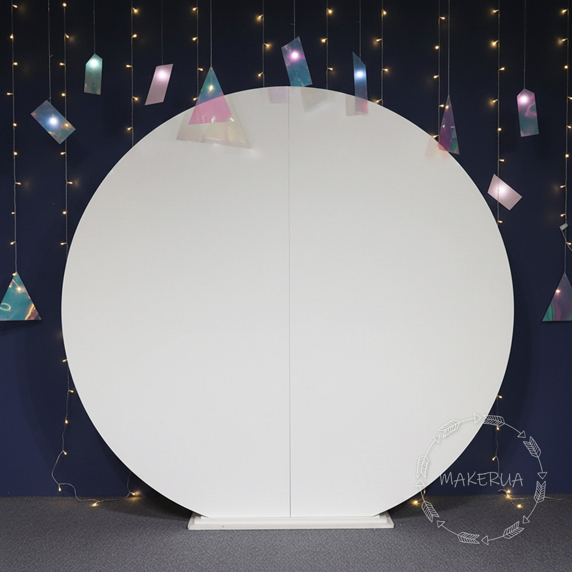 White round backdrop with colorful triangular flags against a dark blue wall with string lights