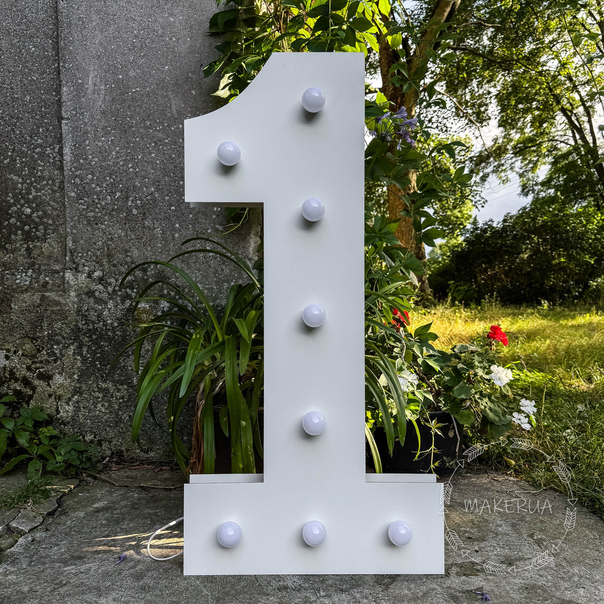 Large white number one with led bulbs in a natural setting